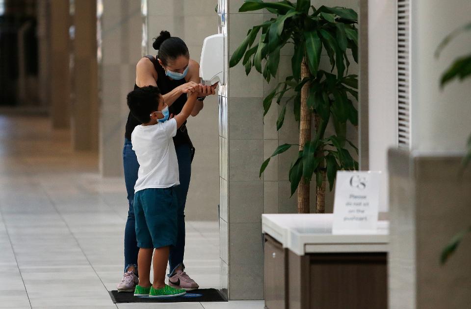 Coronavirus Infections CAMBRIDGE, MA - JUNE 8: A woman and child use hand sanitizer at CambridgeSide in Cambridge, MA ... [+] BOSTON GLOBE VIA GETTY IMAGES